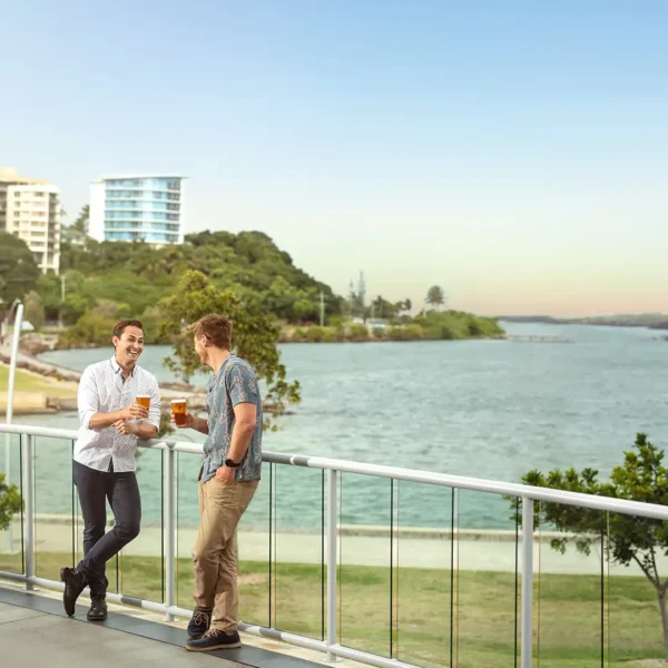 photo of two man casually drinking a beer on the terrace